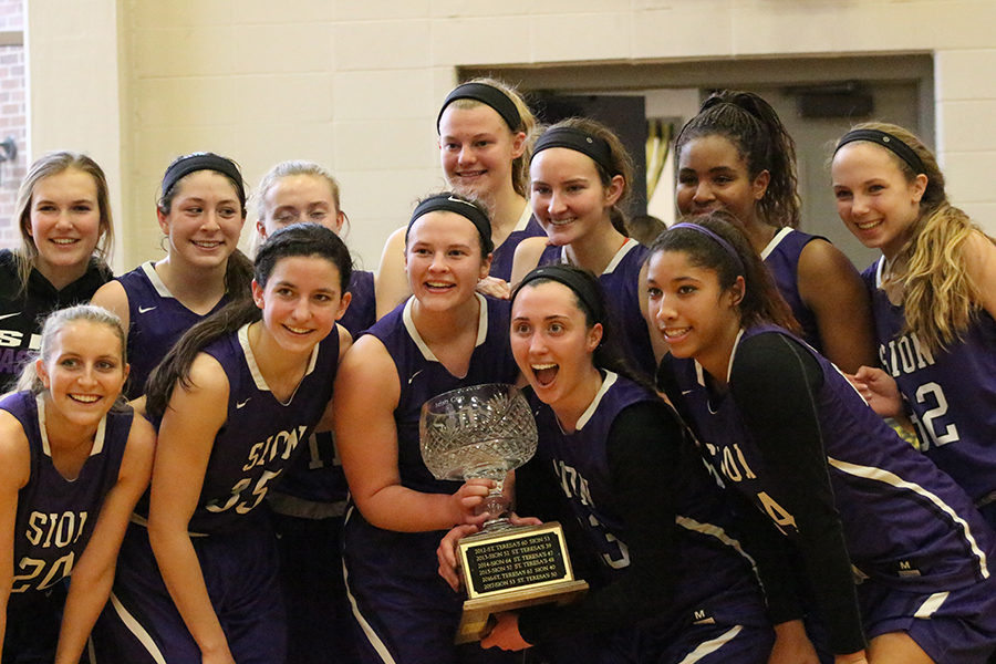 After defeating St. Teresa’s Academy 50-42, the basketball team poses for a picture with the Irish Cup, which they have won for the second year in a row, Saturday, Feb. 24.