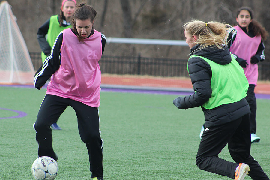 Sophomore Sophia Angrisano and junior Gretta Allen battle for the ball during the purple and white scrimmage March 6.