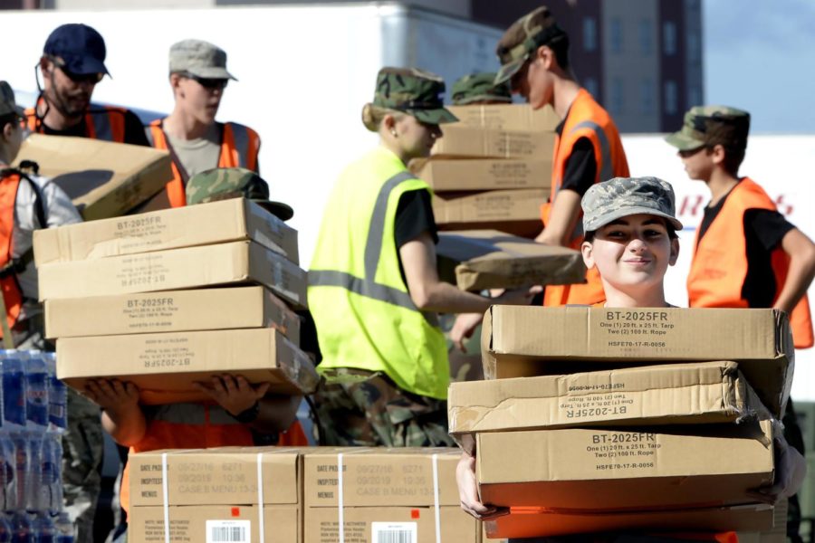 Volunteers carry boxes of tarps to hurricane victims Tuesday, Sept. 18, 2018 in Wilmington, N.C. New Hanover County, in partnership with FEMA, the Civil Air Patrol and volunteers from General Electric, gave out free water, tarps and the Meals Ready to Eat to county residents at three locations in Wilmington. (Chuck Liddy/Raleigh News &amp; Observer/TNS)