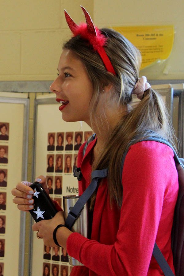 Prior to school, devil-horned senior Emily Rine chats with friends in the commons Sept 11. Students dressed as either devils or angels for the third day of Spirit Week. 