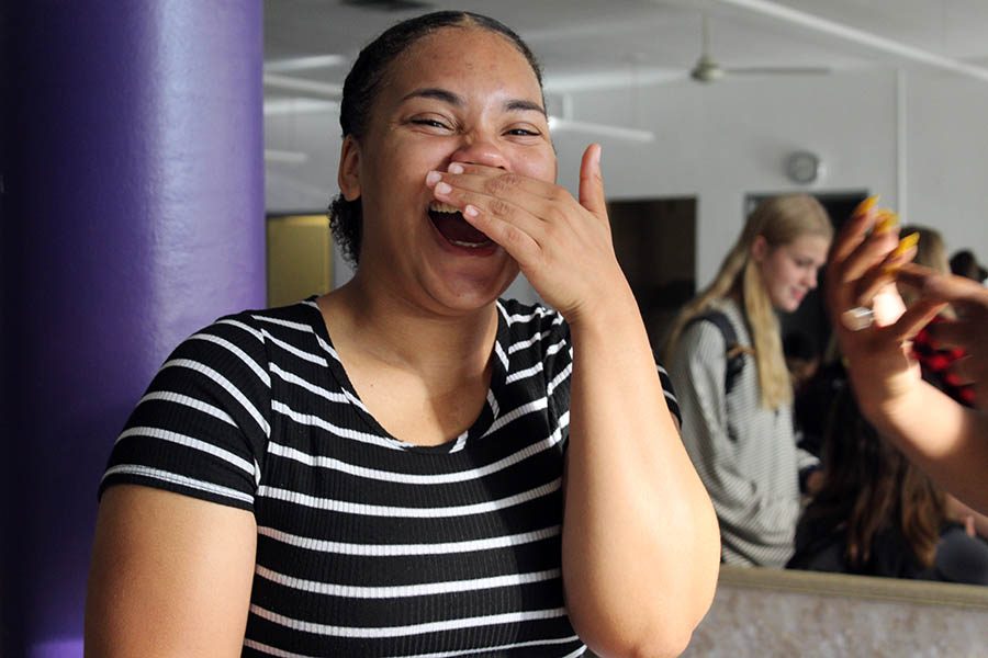 Senior Tehya Frederick laughs at a friend's Pattern Day outfit before school Sept. 9 in the cafeteria. To kick off Spirit Week, students wore patterned clothing for the Pattern Day theme.