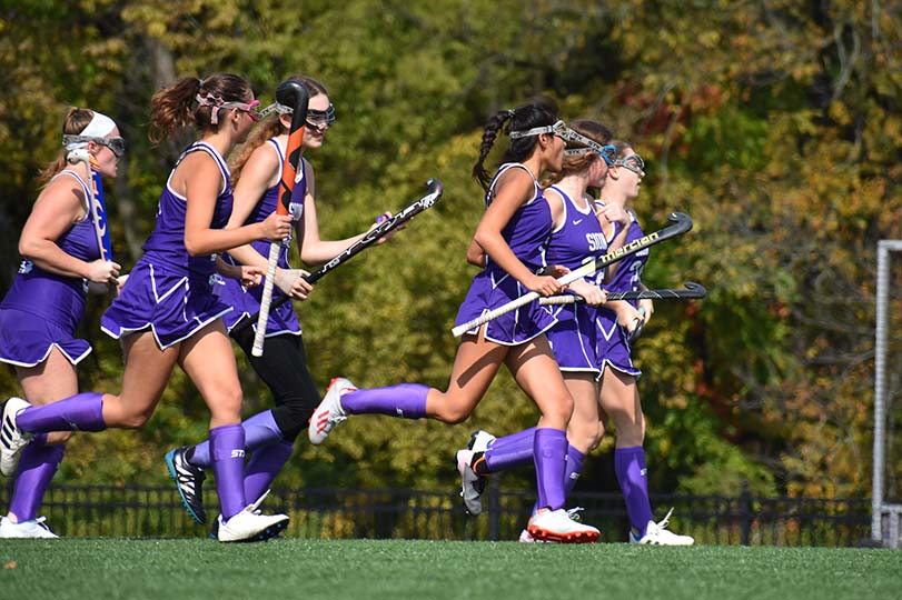 Players run to forward senior Lia Concannon after her goal during the varsity game on Oct. 19, 2019. Varsity won 1-0.