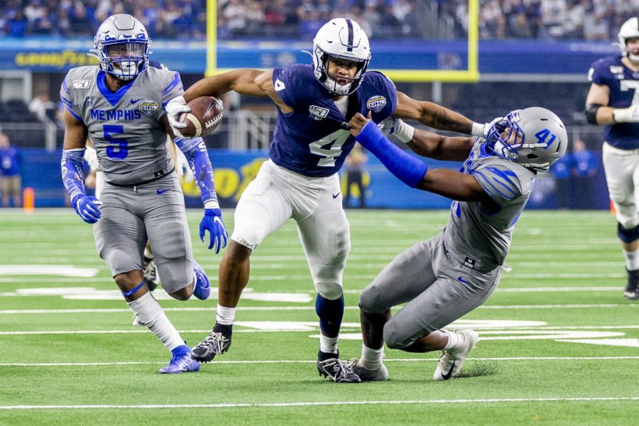 Penn State running back Journey Brown stiff arms Memphis defensive back Sanchez Blake Jr. as he goes 32 yards for a touchdown during the first quarter of the 84th Cotton Bowl in AT&T Stadium,