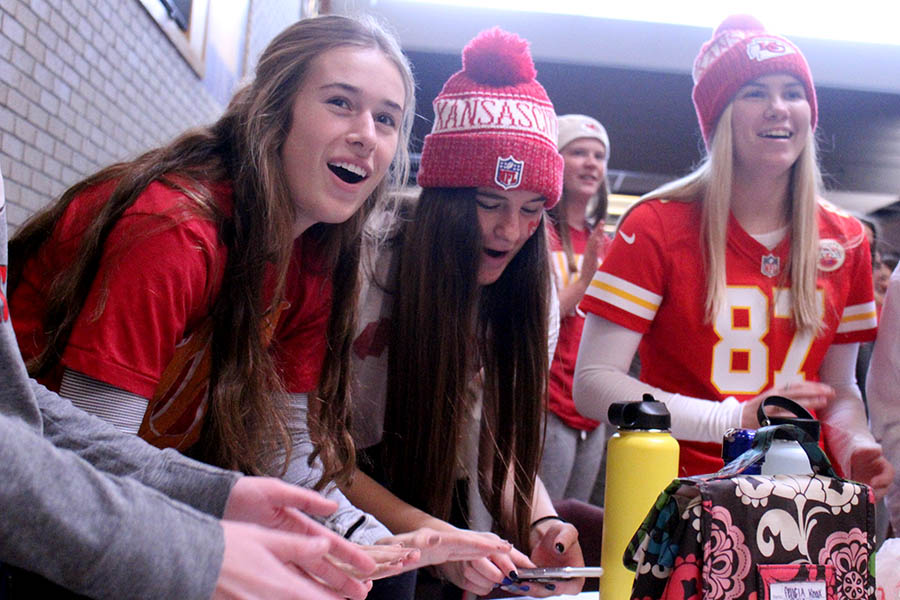 Seniors Felicia Knox, Reilly Jackoboice and Logan Dixon join students in cheering 'Go Chiefs!' during the Red Friday tailgate Jan. 31. During all lunch periods, students were invited to the Grande Salle for the tailgate in support of the Kansas City Chiefs' upcoming Super Bowl LIV game. The tailgate consisted of a concession stand, music and games. 