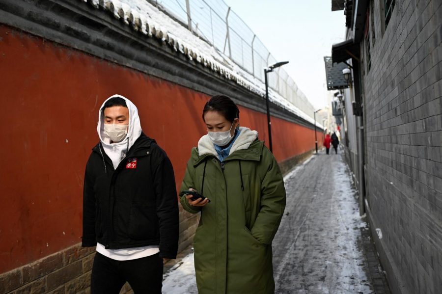 People wearing protective face masks walk through an alley in Beijing on Friday, Feb. 7, 2020. (AFP/Getty Images/TNS)