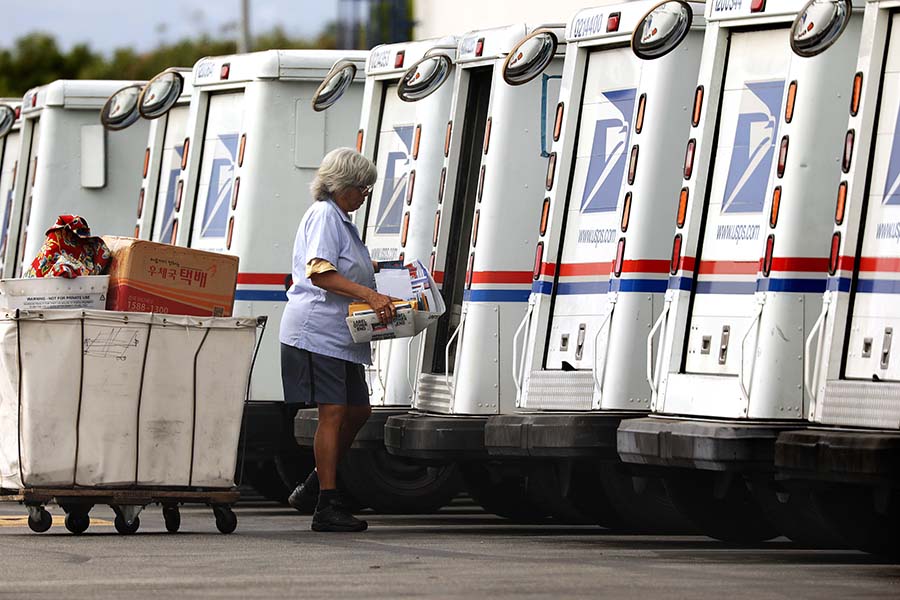 A mail carrier loads a truck for delivery at a United States post office in Torrance, California, on August 26, 2020. (Christina House/Los Angeles Times/TNS)