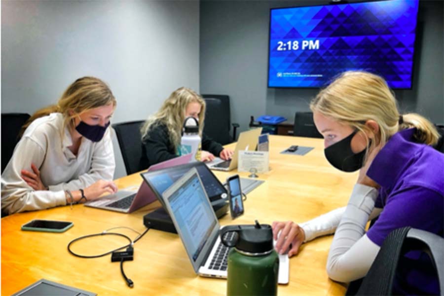 Seniors Mady Jenkins, Hannah McGraw and Violet Tumlin work on their projects for the Designing Real World Impacts class at the Burns & McDonnell headquarters on Sept. 2. 