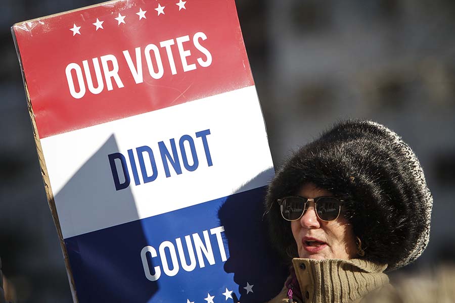 LANSING, MI - DECEMBER 19: Jane Dailey, of Lansing, protests President-elect Donald Trump at a rally at the Michigan State Capitol before the state electoral college met to cast their votes on December 19, 2016 in Lansing, Michigan, United States.  &quot;I know it won&apos;t change anything but I had to do something,&quot; Dailey said.  The electoral college met in the afternoon and voted unanimously for Trump. Electors from all 50 states cast votes today in their respective state capitols.  (Photo by Sarah Rice/Getty Images)