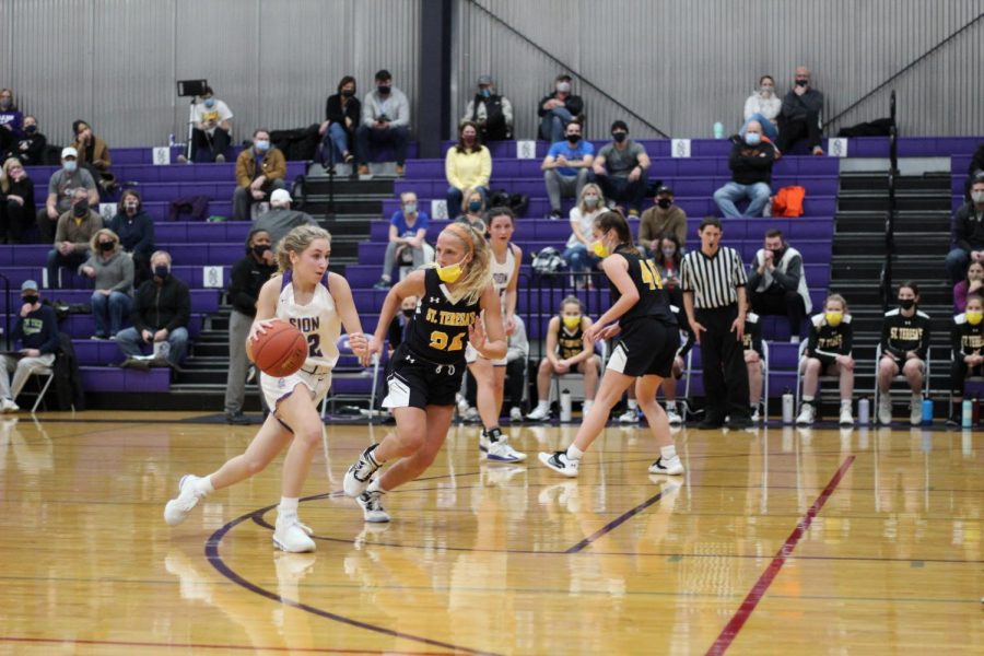 Senior Katelyn Brinkman attempts to escape her guard, Junior Grace Quinn, by dribbling down the lane. 