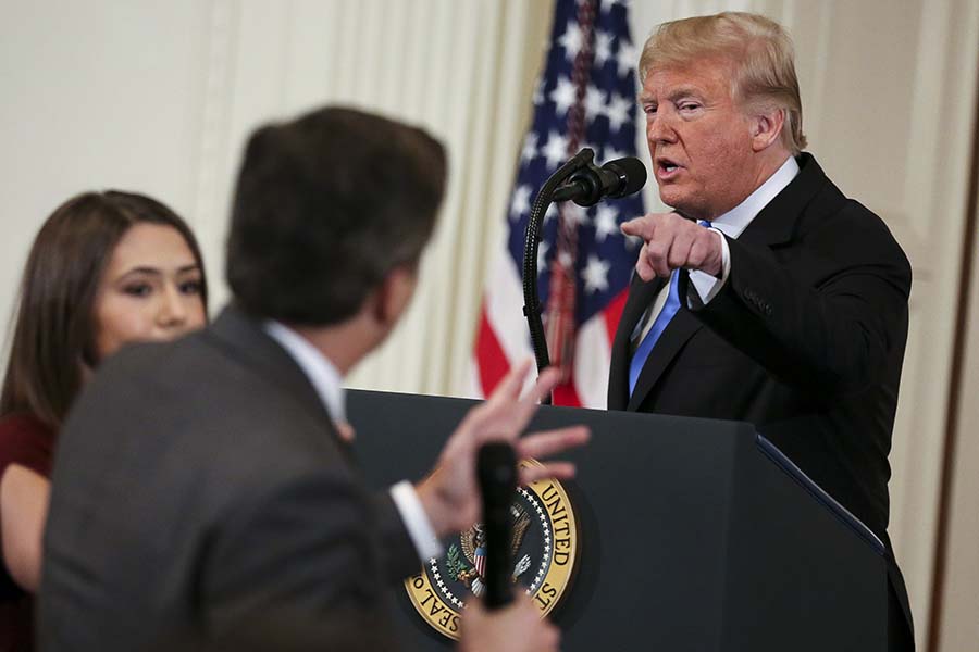 A White House staff member, left, tries to take away the microphone from CNN White House correspondent Jim Acosta during an exchange with President Donald Trump on Wednesday, Nov. 7, 2018, in Washington, D.C. (Oliver Contreras/Sipa USA/TNS)