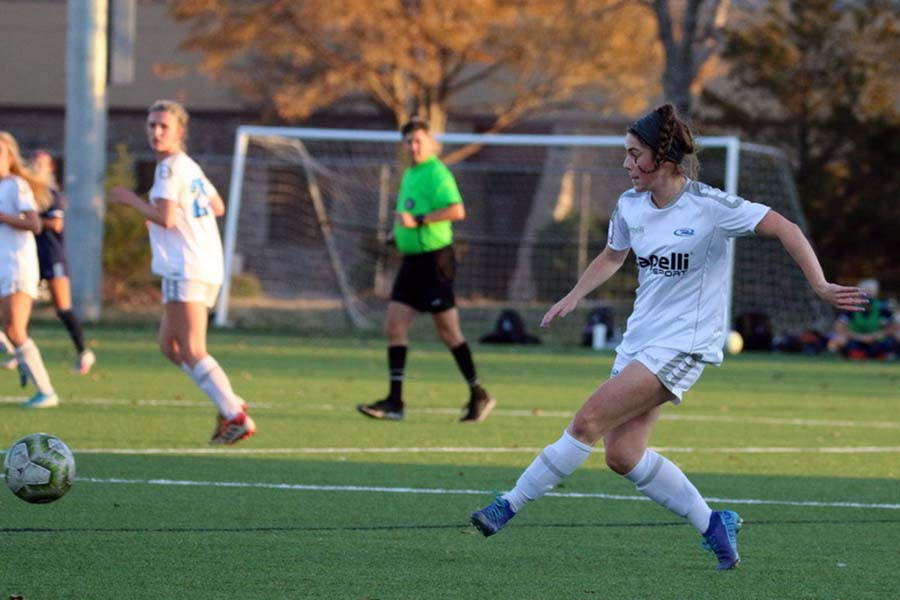 Senior Kennedy Ruark finishes passing the ball to her teammate during her club soccer game.