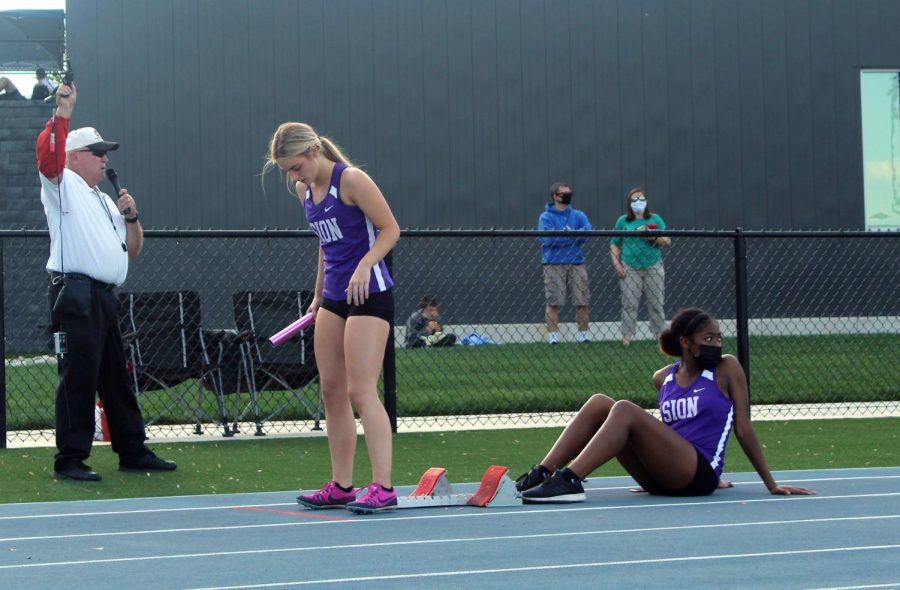 Sophomore Makaila Traylor helps senior Paxton Misemer prepare for the 4x200 relay.