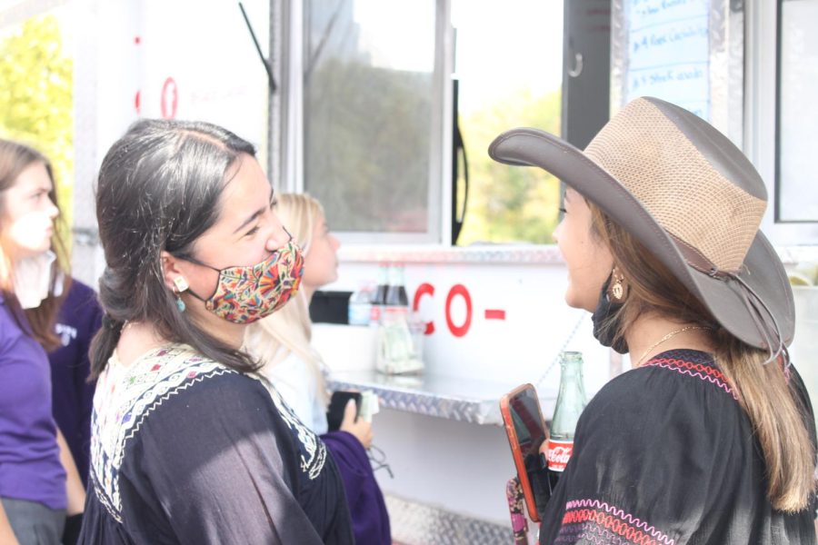 Junior Samy Mora Cuevas laughs with senior Vivi Calderon while waiting for their tacos in front of the Taco Cacao taco truck.