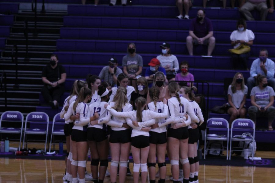 Varsity huddles after their first match to regroup and make their comeback in the following three sets.