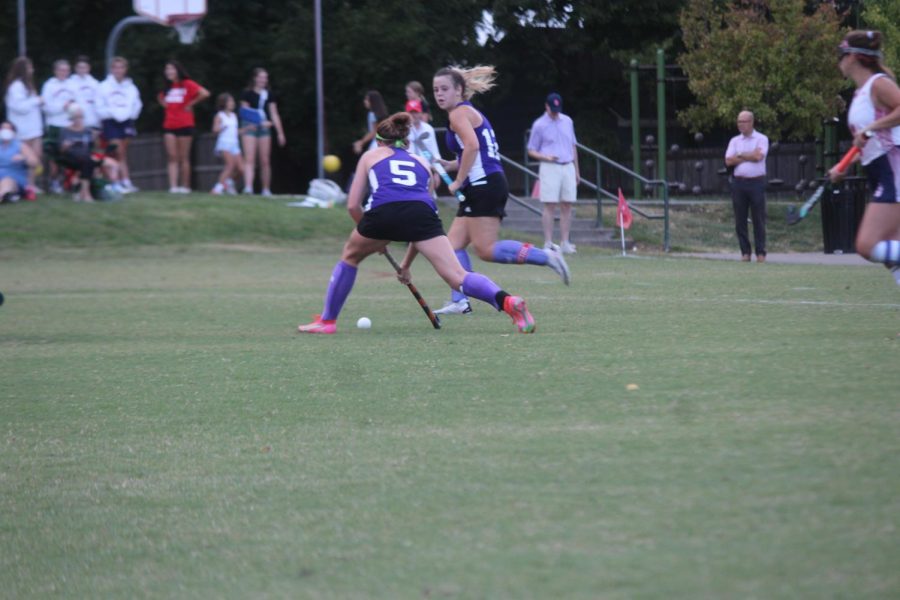 Members of the team hit the ball with her stick. 