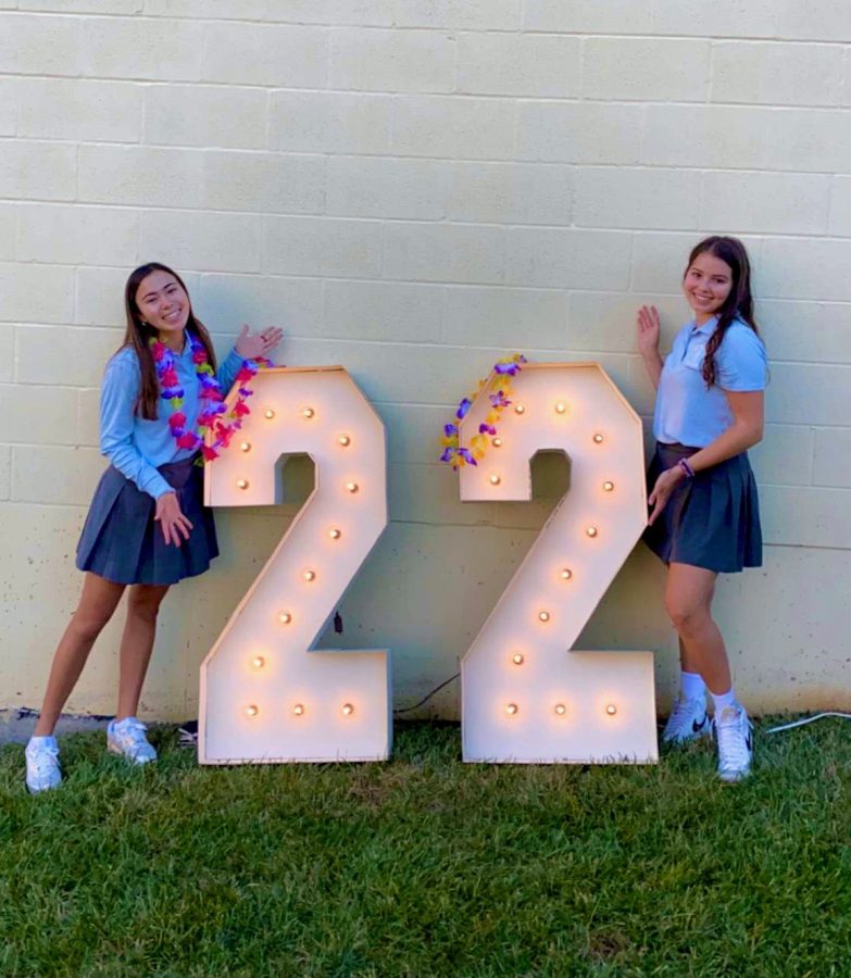 Senior Lizzy Hoffman and I lean against the lit up numbers in the courtyard during the senior tailgate on the first day of school in August. The leis and numbers were a surprised to the seniors organized by the Sion counselors.