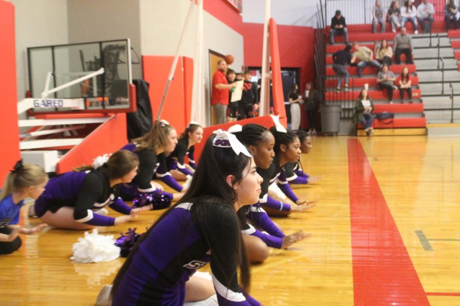 The Sion Cheer Team claps their hands on the floor to rally up school spirit. 