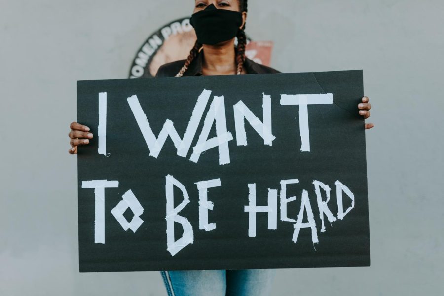 Woman displays poster reading, "I want to be heard". Similar posters were used during the protests against gun violence in June of 2020. 