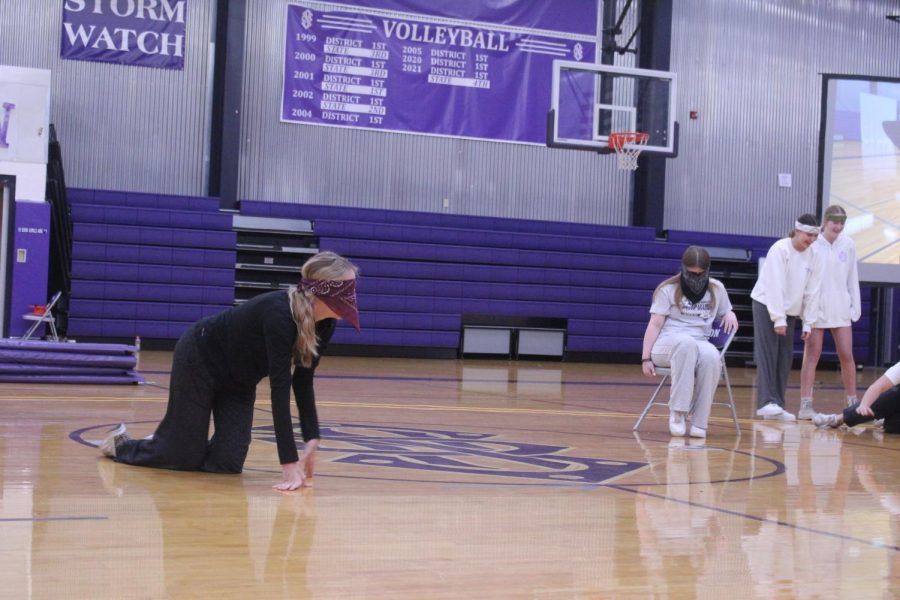 Senior Sophia McClure crawls, trying to find a chair to sit on. 