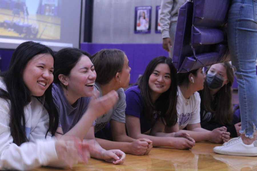 Members of the junior class laugh with each other, as they are preparing for the human log roll. 