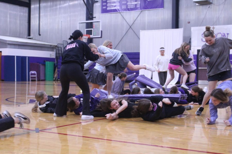 Senior Carmen Phillips lets her senior classmates roll her along to the other side of the gym