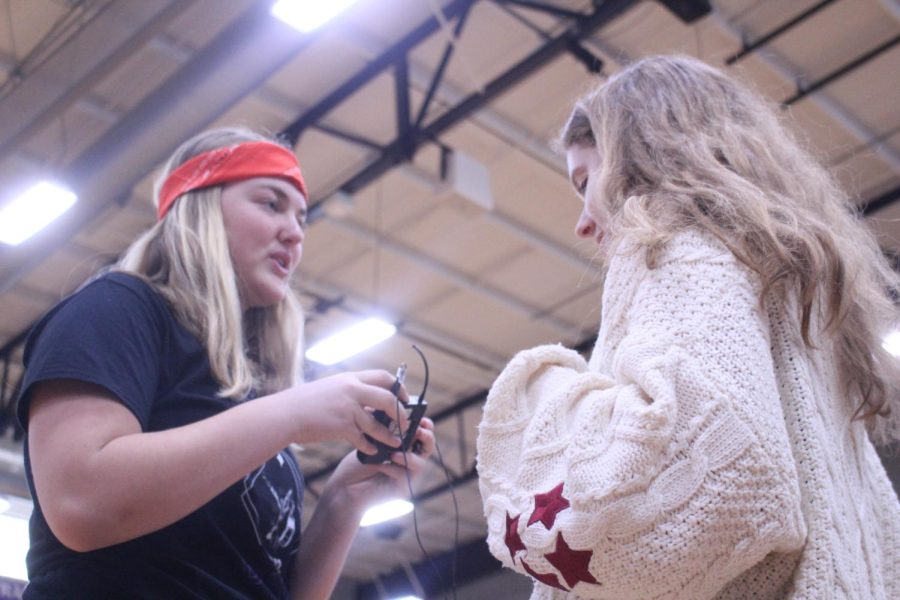 STUCO member Lucy Shively and junior Chloe Welch are discussing the listening game which all the grades are playing.