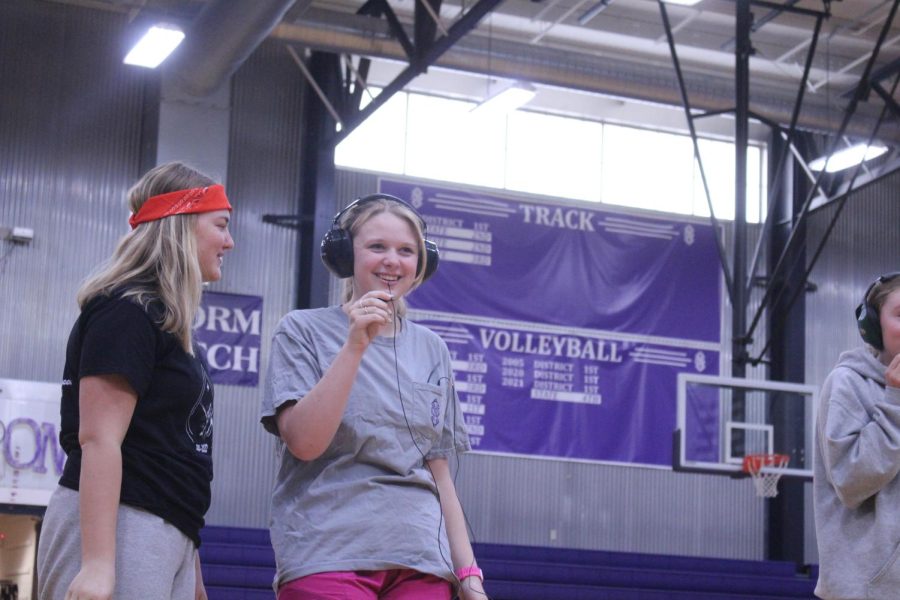 Junior Addie Heistand has headphones on trying to listen to what her partner is saying. 