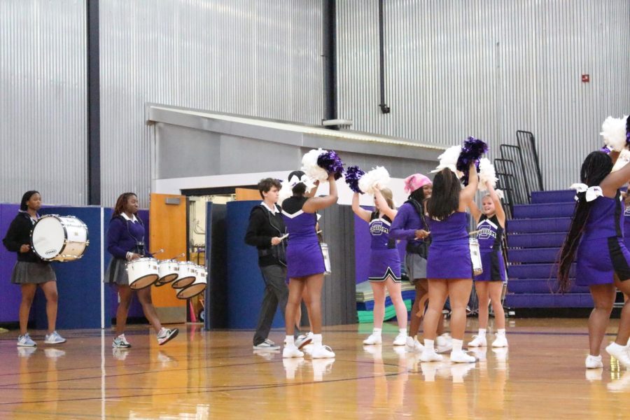 The drumline enters the tunnel created by the cheer team at Thursday's fall sports pep rally 