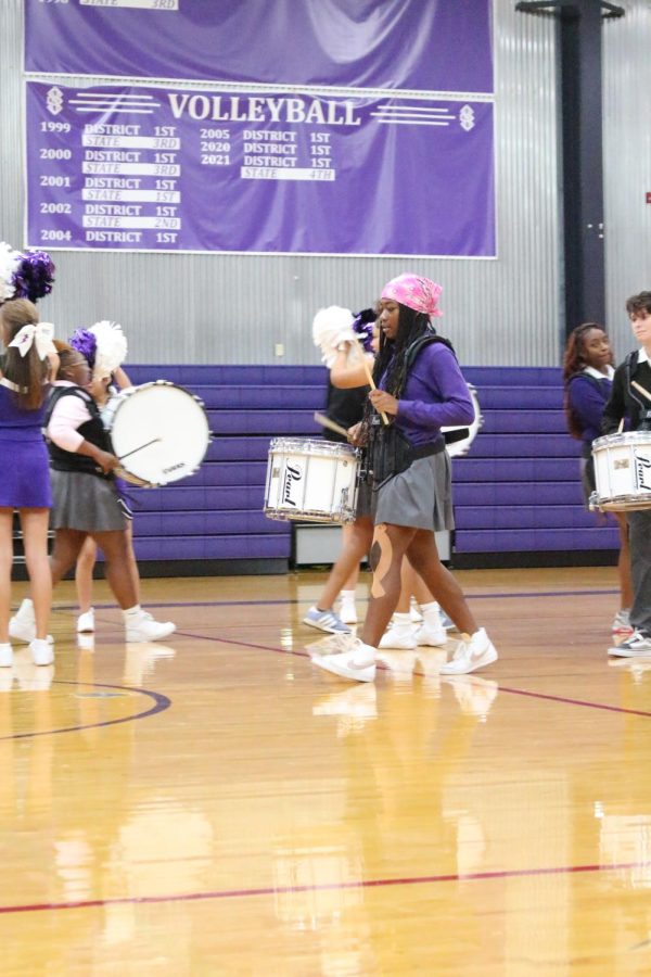 Senior Makaila Traylor bangs on her drum during drumline's performance 