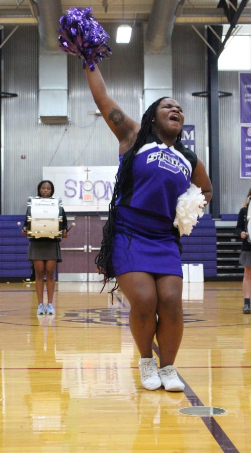 Junior Imani Cutler leads the crowd during the cheer team's performace at the fall sports pep rally 