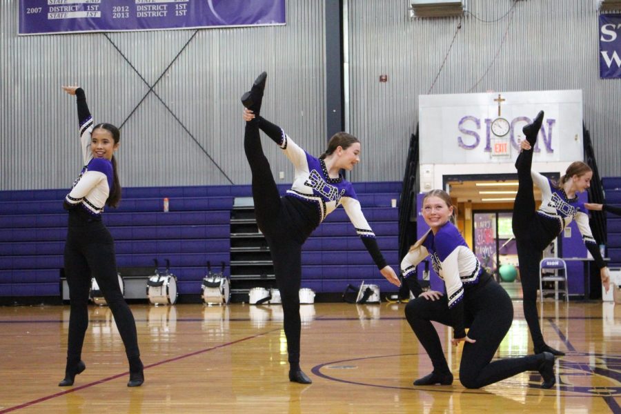 Sophomore Téah Calini holds a stilt while leaning on junior Natalie Stapp for support 