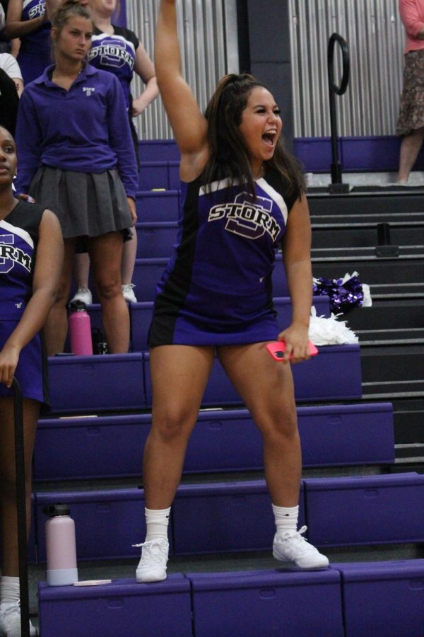 Junior Gianna Collins throws her arm up in excitement during the cheers 