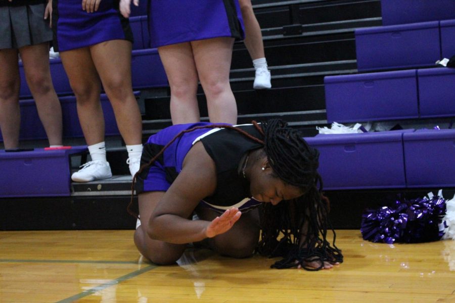 Junior Imani Cutler bangs on the floor during the "I believe" cheer