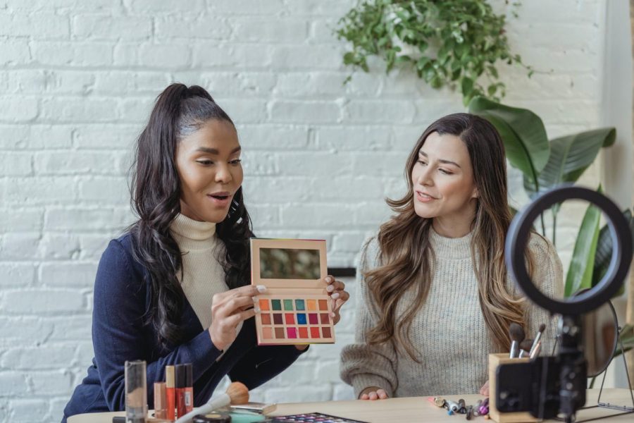 Two beauty influencers show off an eyeshadow palette on social media. 