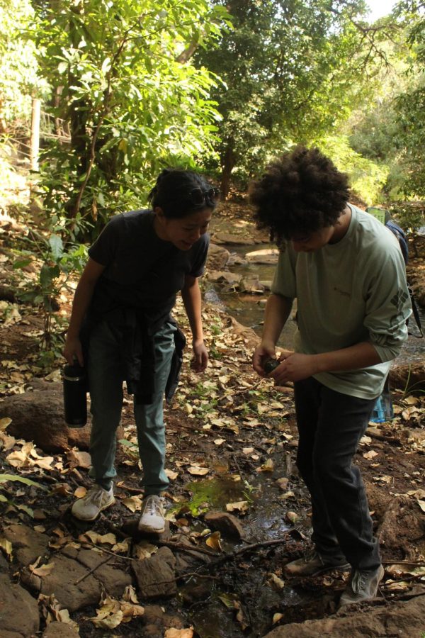 While hiking Junior Mary Margret Perkins and director of STEAM Emilie Lai stop to pick up something they saw on the ground.