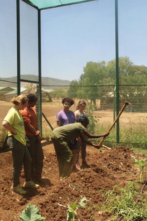 Kuresh Hassan, who works at the school, teaches the Young Conservationists how to garden and till the ground.