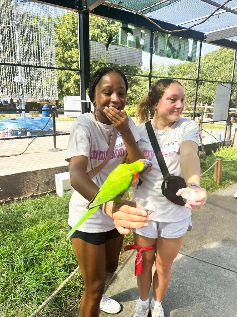 At the zoo, freshman Sabrina Staley holds a parrot on her right arm. Staley was accompanied by freshman Rylie Cobb-Taylor. Freshman and senior peer ministers visited the zoo on August 27 for freshman retreat. 