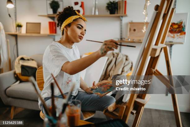 Photo of young females artist in her apartment